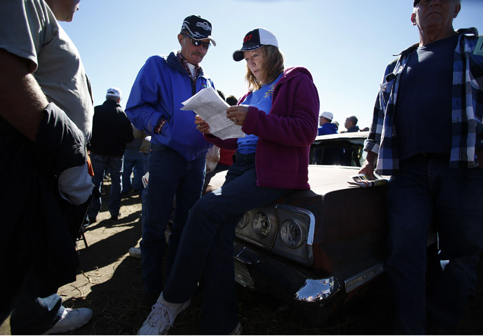 Potential buyers and car enthusiast Rick Fitzler, left, and Gail Meisner monitor the bids as the vintage automobiles from the Lambrecht Collection are put up for auction in Pierce, Nebraska, September 28, 2013. Over 500 classic cars and trucks from an inventory collected by Ray and Mildred Lambrecht will be sold over the weekend. REUTERS/Jim Urquhart  (UNITED STATES)